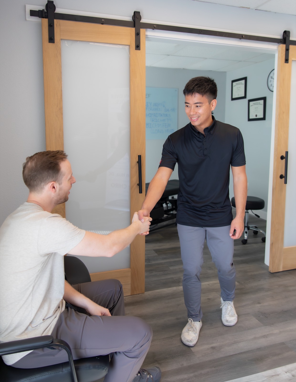 Dr. Jaron Hua greeting a patient at the door of his treatment room at G3 Chiro in Newport Beach