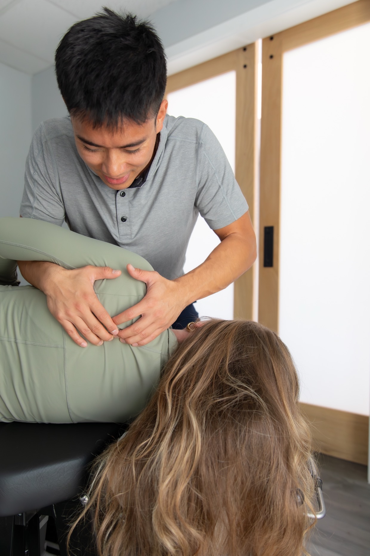 Dr. Jaron Hua treating a patient's mid back by hand at G3 Chiro in Newport Beach